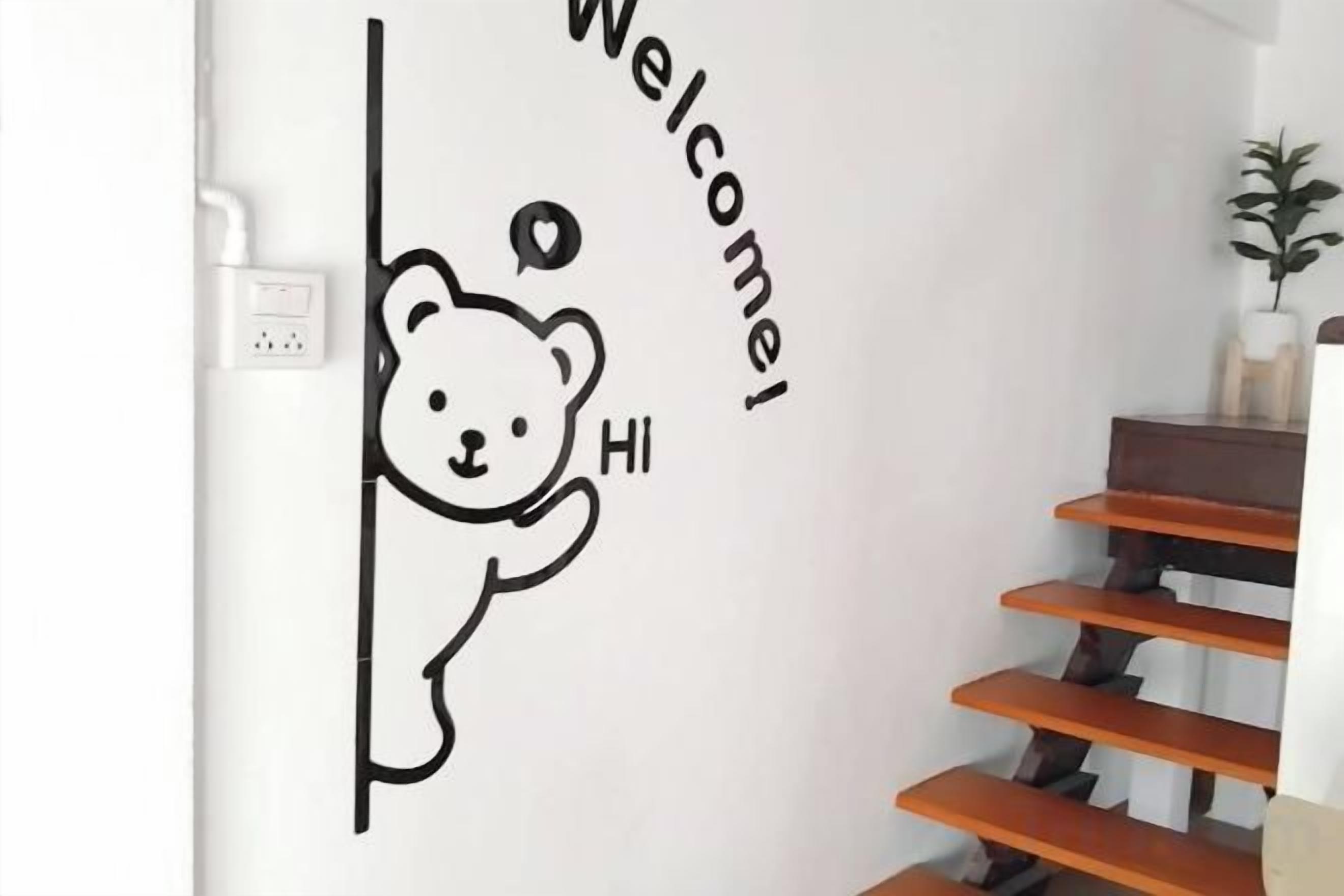 A wall with a bear sticker saying 'Welcome' and 'Hi'.