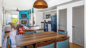 A modern kitchen with a central island, built-in appliances, and a dining area with a wooden table and chairs.