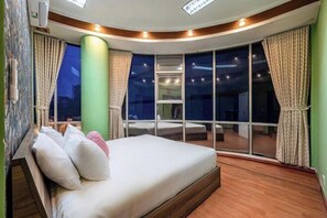 A bedroom with a bed, a large window, and a view of the night sky. - An Corner - My Vinh Apartment - Central D3 (Ho Chi Minh City)