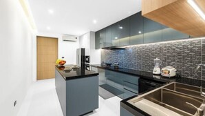 Una cocina moderna con una isla central, electrodomésticos integrados y salpicadero.