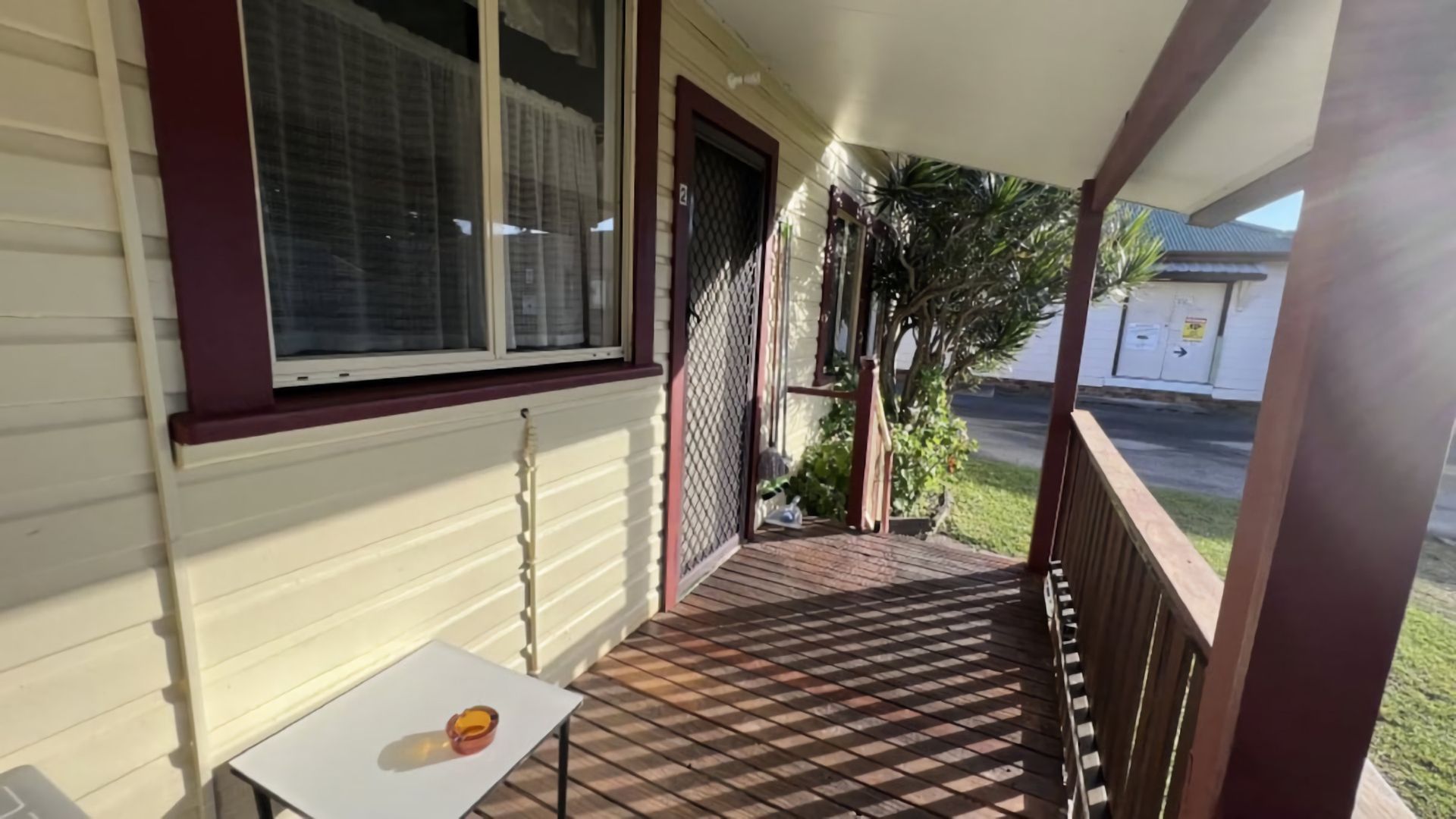A covered porch with a table and a window.