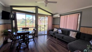 Una habitación con una mesa de comedor, sillas, un sofá y una televisión.