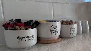 Three white containers with different labels on a kitchen counter.