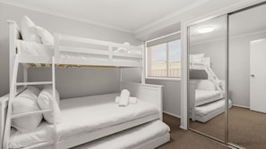 Habitación con literas, un espejo y una ventana.
