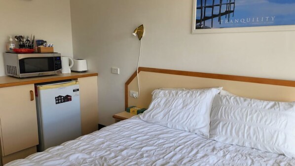 A hotel room with a bed, a microwave, a refrigerator, and a nightstand. - Jopen Motel Unit 1 ~ Stress-free, affordable, and comfortable (Sussex Inlet)