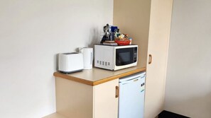 A kitchenette with a microwave, toaster, and a small refrigerator. - Jopen Motel Unit 3 ~ Stress-free and comfortable! (Sussex Inlet)