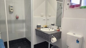 A bathroom with a white sink, a mirror, a towel rack, and a toilet. - Jopen Motel Unit 4 ~ Stress-free and comfortable accommodation! (Sussex Inlet)