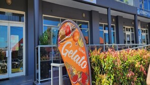 Une devanture de magasin avec une enseigne indiquant « GIMA Gelato », où l’on peut voir une variété de fruits.