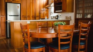Eine Holz-Küche mit einer Kochinsel, Stühlen und einem Kühlschrank.