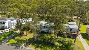 A residential area with detached houses, a paved driveway, and a lawn.