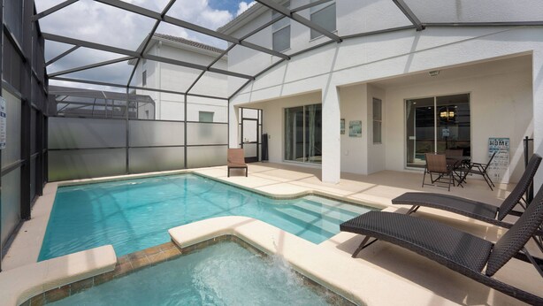A swimming pool with lounge chairs and a covered patio area. - Storey Lake Resort | 6BR Villa w/ Pool Near Disney (Kissimmee)