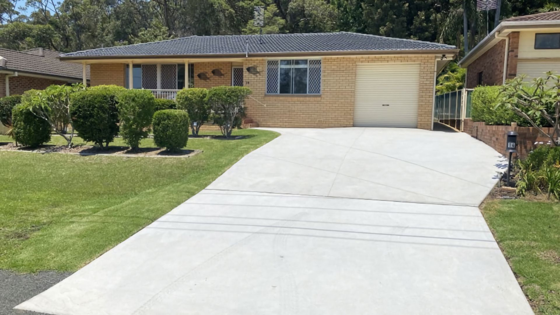 A residential house with a garage, a driveway, and a well-maintained lawn.