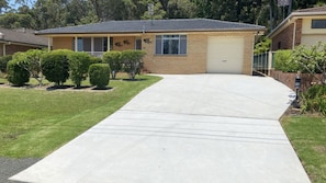 A residential house with a garage, a driveway, and a well-maintained lawn.
