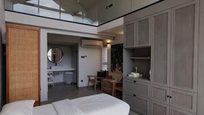 A bedroom with a bed, a desk, a chair, and a wardrobe.