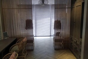 A room with a herringbone floor, a wooden partition with vertical slats, a ceiling fan, and a view through the partition to a room with a bed. - Talula Hill Farmstay Kluang (Kluang)