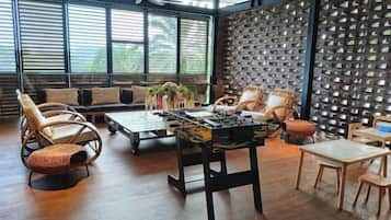 A spacious room with a large window, a ceiling fan, and a wall with a unique pattern.