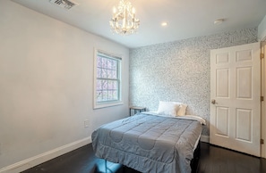 A bedroom with a bed, a chandelier, a window, and a door. - Lovely 4-bedroom house in Meriden (Meriden)