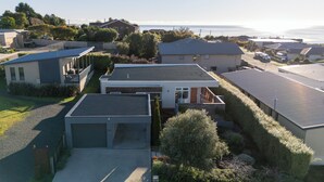 Un quartier résidentiel avec des maisons modernes, un garage et une vue sur la mer.