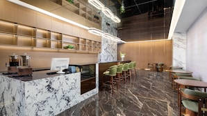 A modern lobby with a marble reception desk, seating area, and a high ceiling with lighting fixtures. - Days Inn by Wyndham Zhuhai Qinglv Road (Zhuhai)