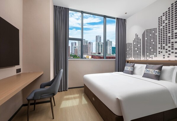 A modern hotel room with a large bed, a desk, and a city view through the window. - Days Inn by Wyndham Zhuhai Qinglv Road (Zhuhai)