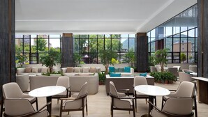 A modern lounge area with sofas, tables, and potted plants. - Ramada Encore By Wyndham Enshi Huaxi Valley (Enshi)