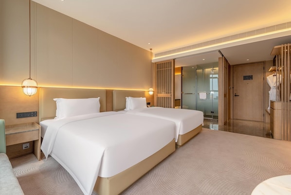 A modern hotel room with two large beds, a bedside table, a wardrobe, and a bathroom visible through an open door. - Wyndham Garden Shanghai Songjiang (Shanghai)
