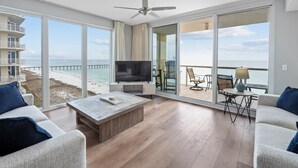 A spacious living room with a large TV, wooden coffee table, and comfortable seating.