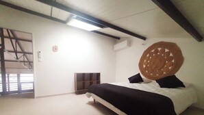 Un dormitorio con cama, cabecera de madera, chimenea y ventana grande.