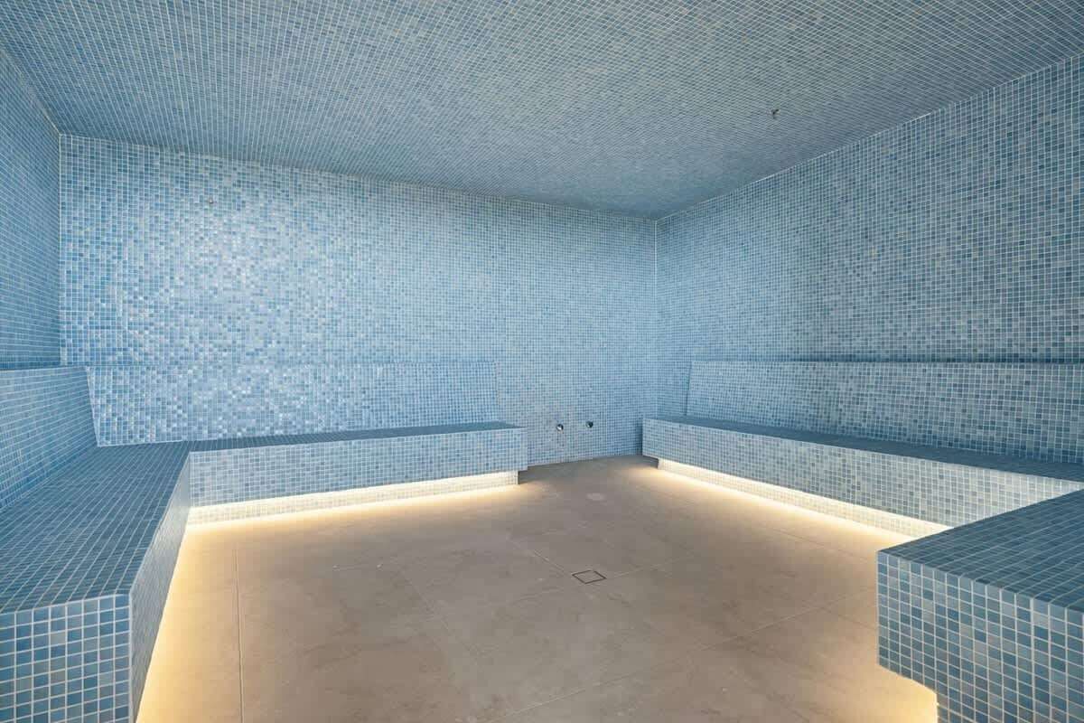 A tiled room with benches along the walls and a central open space.