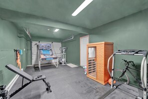 Ein Fitnessraum mit Trainingsgeräten, Laufband und Fahrrad.