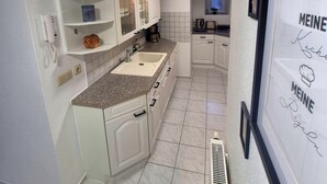 Una cocina moderna con armarios blancos, encimera de granito y horno empotrado.