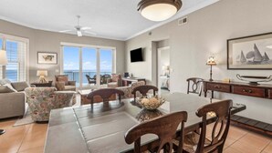 A spacious living area with a dining table, chairs, a sofa, and a TV.