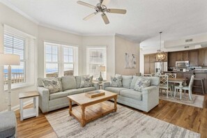 A spacious living room with a sofa set, a coffee table, and a dining area with a table and chairs.