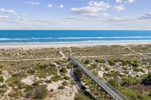 A beach with a wooden boardwalk leading to the shore.