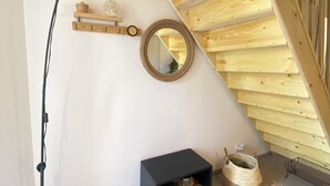 A corner of a room with a black floor lamp, a small black cabinet, a woven basket, and a patterned rug. - L'An'Phi- Charming house with outdoor spa (Vaison-la-Romaine)