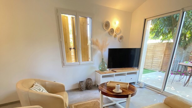 A modern living room with a sofa set, a coffee table, and a flat-screen TV. - L'An'Phi- Charming house with outdoor spa (Vaison-la-Romaine)