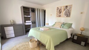 A bedroom with a bed, a bedside table, a nightstand, a wardrobe, and a bathroom with a shower curtain. - L'An'Phi- Charming house with outdoor spa (Vaison-la-Romaine)