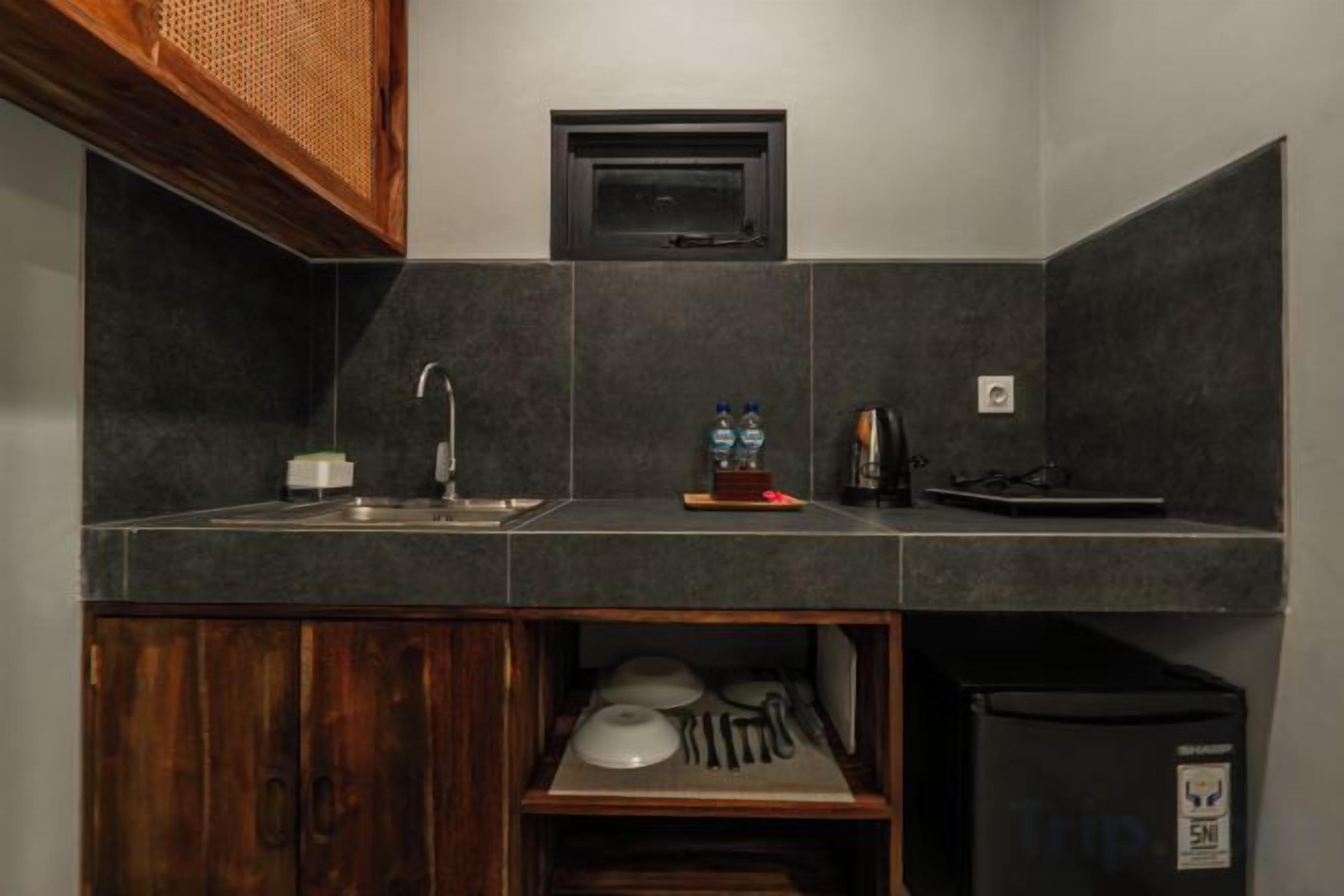 A compact kitchen with a microwave, sink, and a small refrigerator.