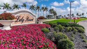 A sign for Lely Resort with a landscaped garden in the foreground. - Lakefront Retreat in Prestigious Master Reserve at Lely Resort (Naples)