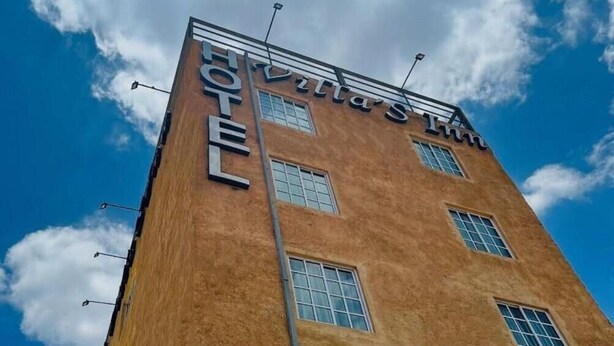 A tall building with the sign "Villa St. HOTEL" on the side. - Hotel VillaS INN (León)