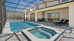 Una piscina interior con techo de cristal, sillas de descanso y un área de patio con mesas y sillas.
