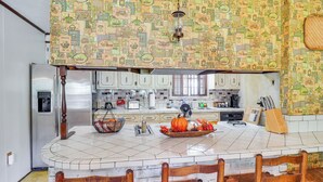 A kitchen with a central island, white cabinets, and a patterned backsplash. - Rural Retreat: ‘Cypress Lake’ By Roosevelt St Park (Morton)