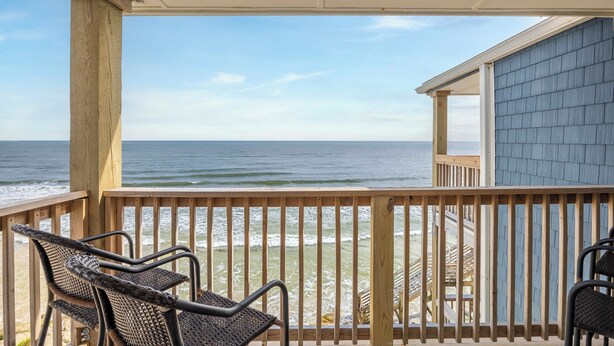 A covered outdoor area with a view of the ocean, wooden deck, and beach chairs. - Steps to Sand! 3rd-Floor North Topsail Beach Condo (North Topsail Beach)
