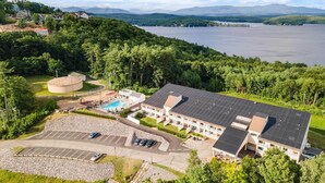 Un hotel con piscina, paneles solares y aparcamiento.