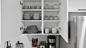 A kitchen with white cabinets, a coffee maker, and a toaster. - Bright & Modern 2BR Basement Suite w/ Rustic Bar & Private Entrance (Kingston)