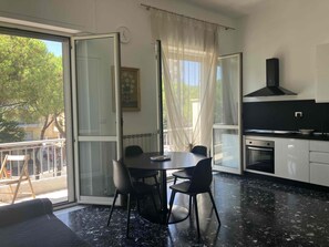 Una cucina moderna con zona pranzo, ampie finestre e vista all'esterno.
