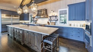 A spacious kitchen with a large island, wooden cabinets, and stainless steel appliances.