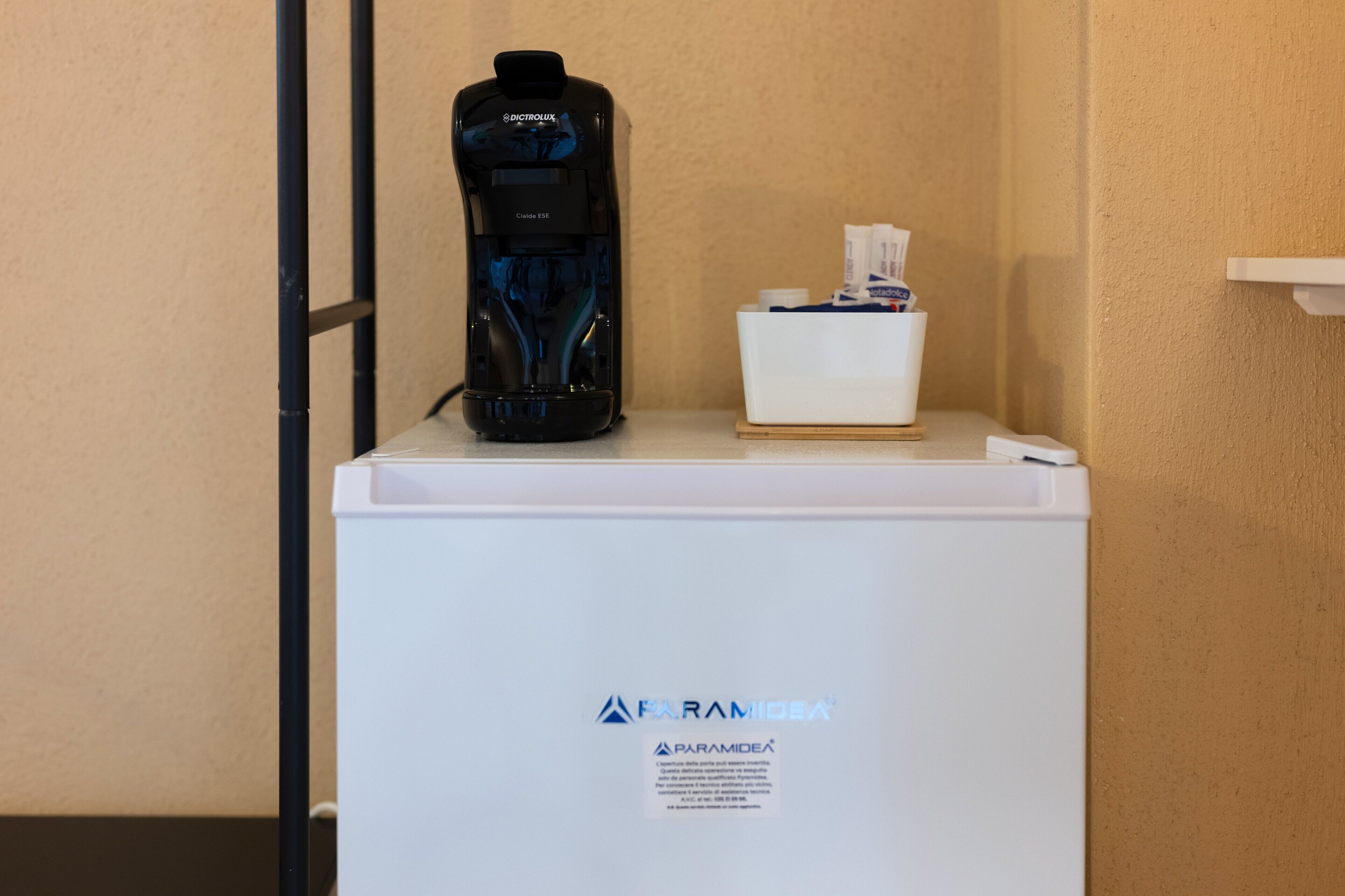 A white refrigerator with a black coffee maker on top and a tissue box beside it.