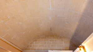 A room with a stone ceiling, a white wall, and a light fixture. - Bed and Breakfast 'Super Luxury' with Private Garden, Wi-Fi and Air Conditioning (Massafra)