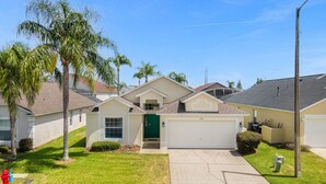 A single-story house with a green front door, a garage, and a driveway. - 4 Bedroom home with games room & pool in gated community (Davenport)